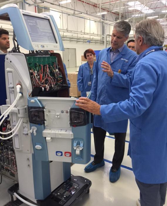 Image of Joe Almeida talking with employees at a manufacturing facility in Colombia